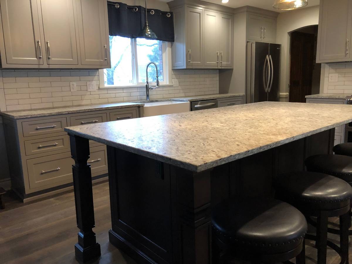 Greige shaker kitchen with black painted island, granite counters, and subway tile backsplash