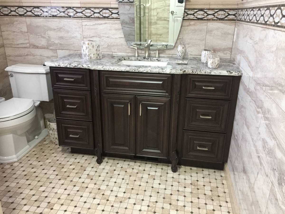 Bathroom with dark wood vanity, granite top, and mosaic tile trim
