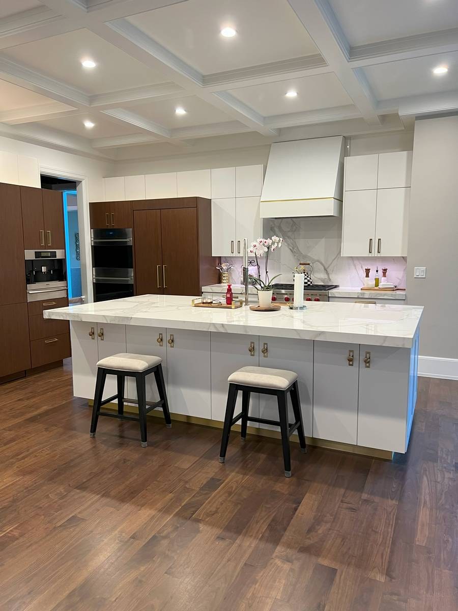 Luxury custom kitchen with coffered ceiling, waterfall marble island, and walnut pantry — example of Odyssey Construction's work