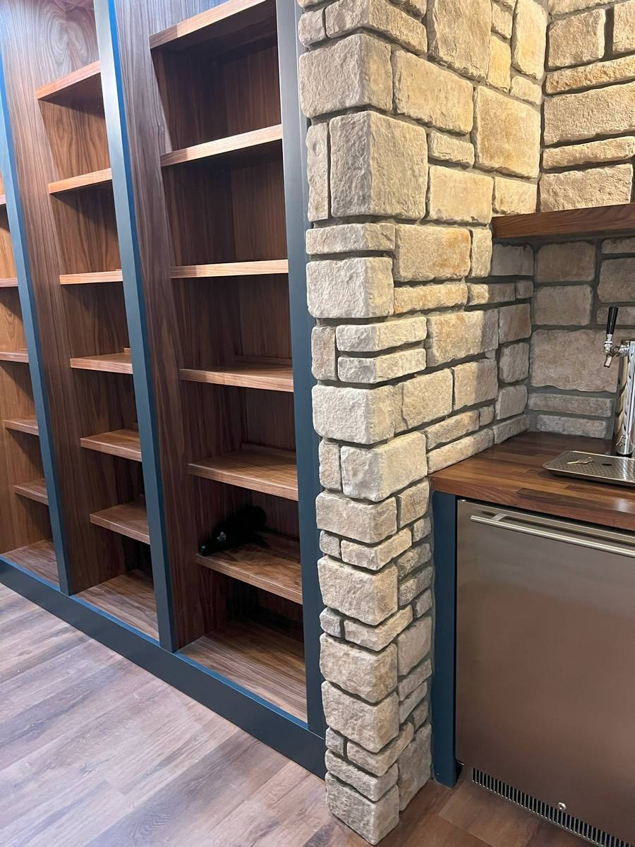 Finished basement with custom cabinetry, bar area, and premium flooring