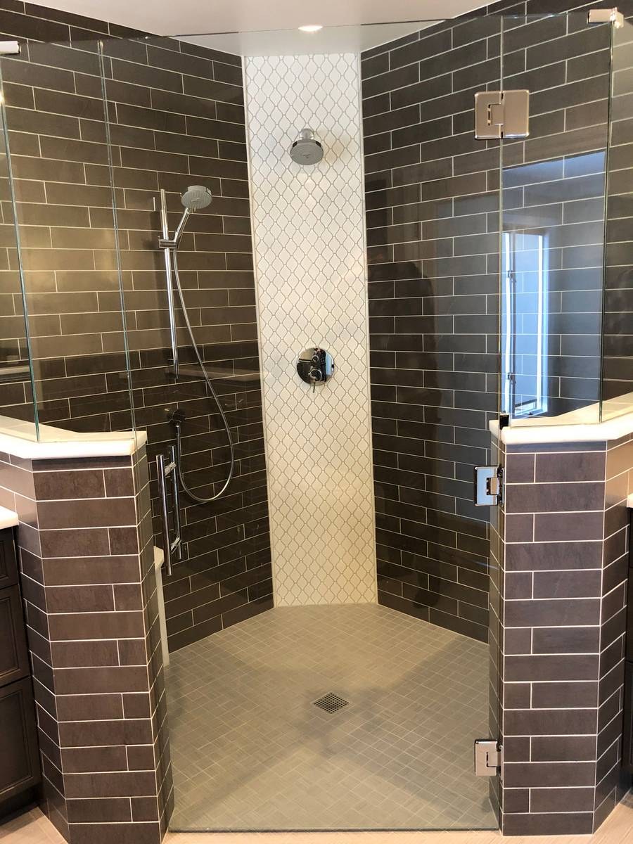 Walk-in shower with dark brown subway tile walls and arabesque mosaic accent column