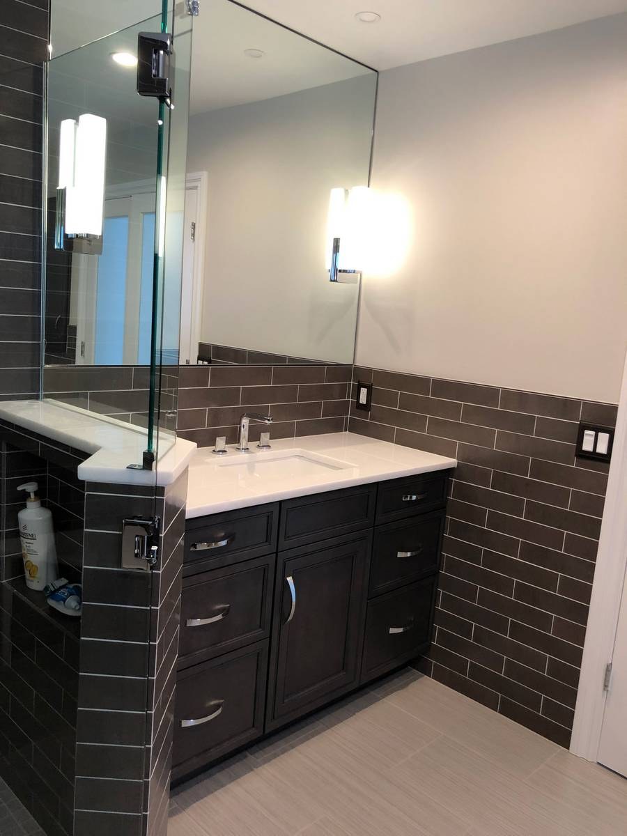 Dark shaker vanity with white quartz countertop and subway tile wainscoting