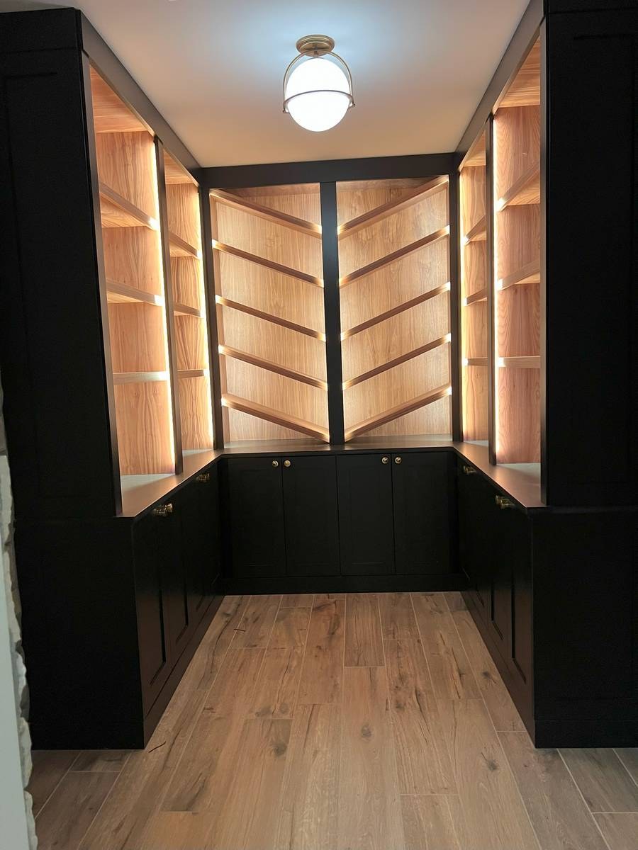 Custom wine cellar with LED-lit cedar shelving, arched racking, and ambient lighting