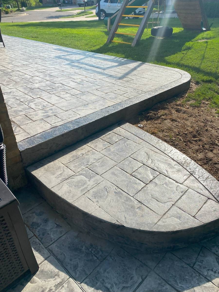 Stamped concrete patio with rounded step landing and grey stone pattern finish