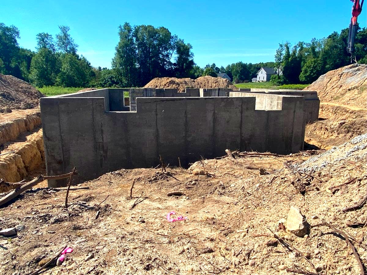 Concrete foundation perimeter with anchor bolts set, ready for sill plate and framing