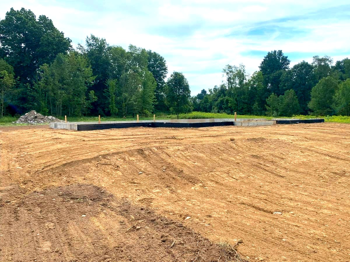 Fresh footings and slab on cleared lot at the start of custom home build