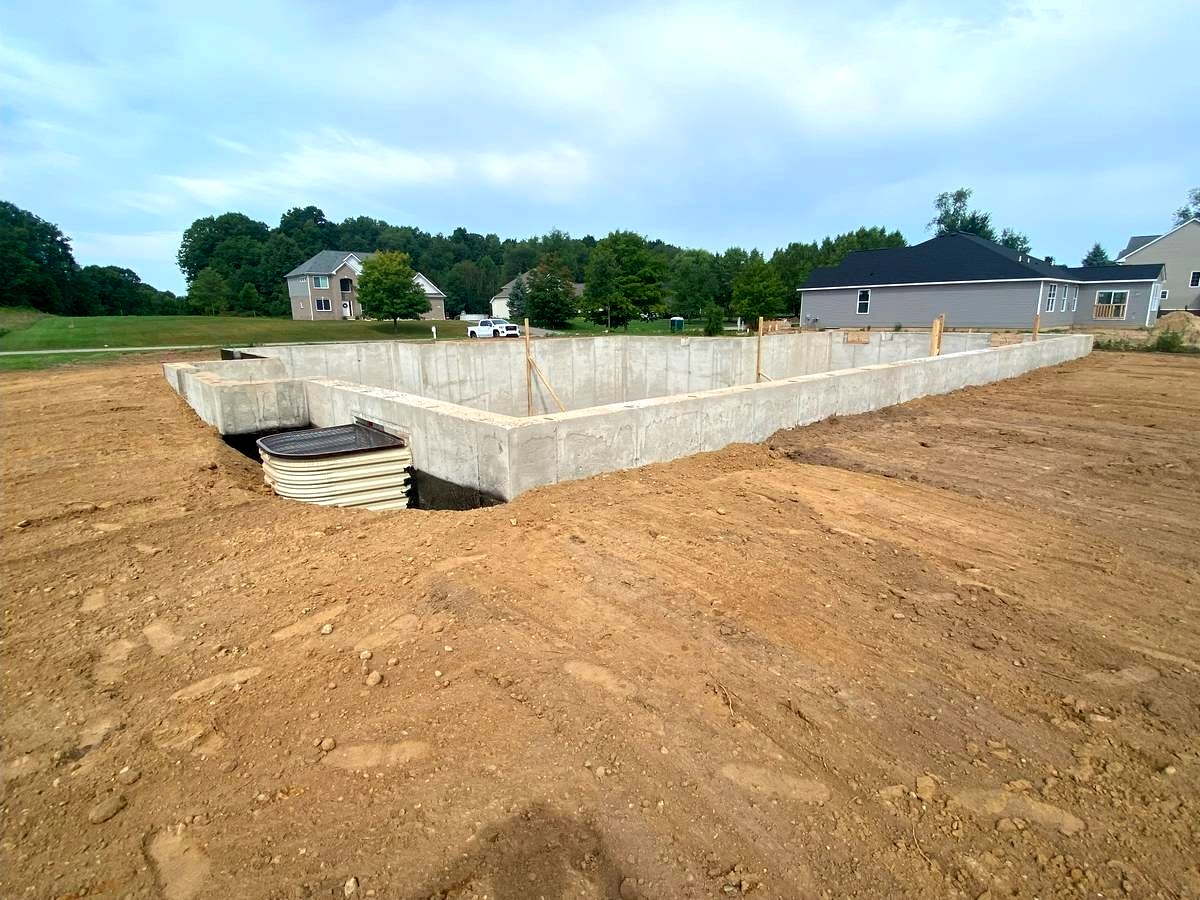 Poured concrete foundation walls with stub-out utilities and waterproofing in progress