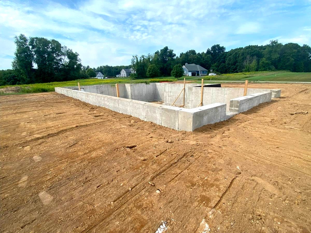 Custom home foundation walls viewed from lot level, ready for backfill