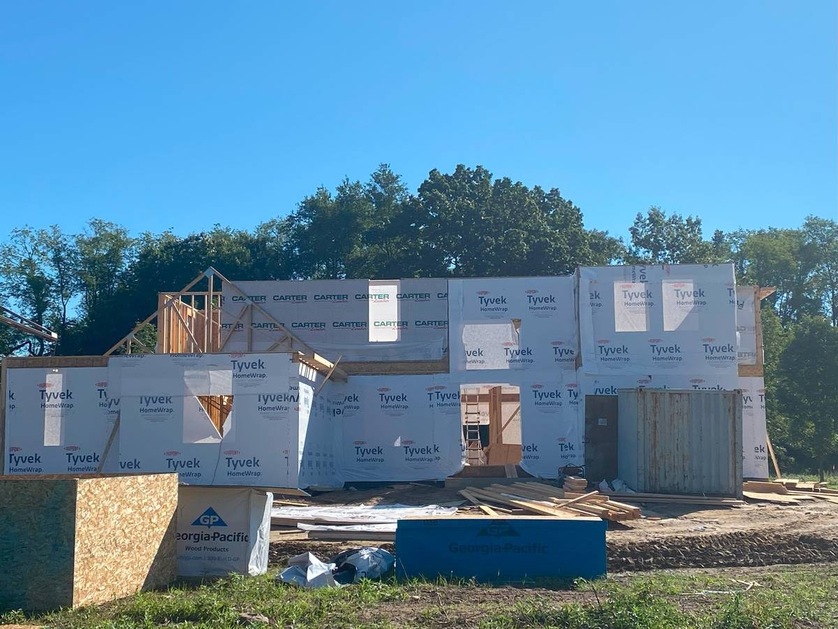 Framed and Tyvek-wrapped two-story custom home exterior at dried-in stage