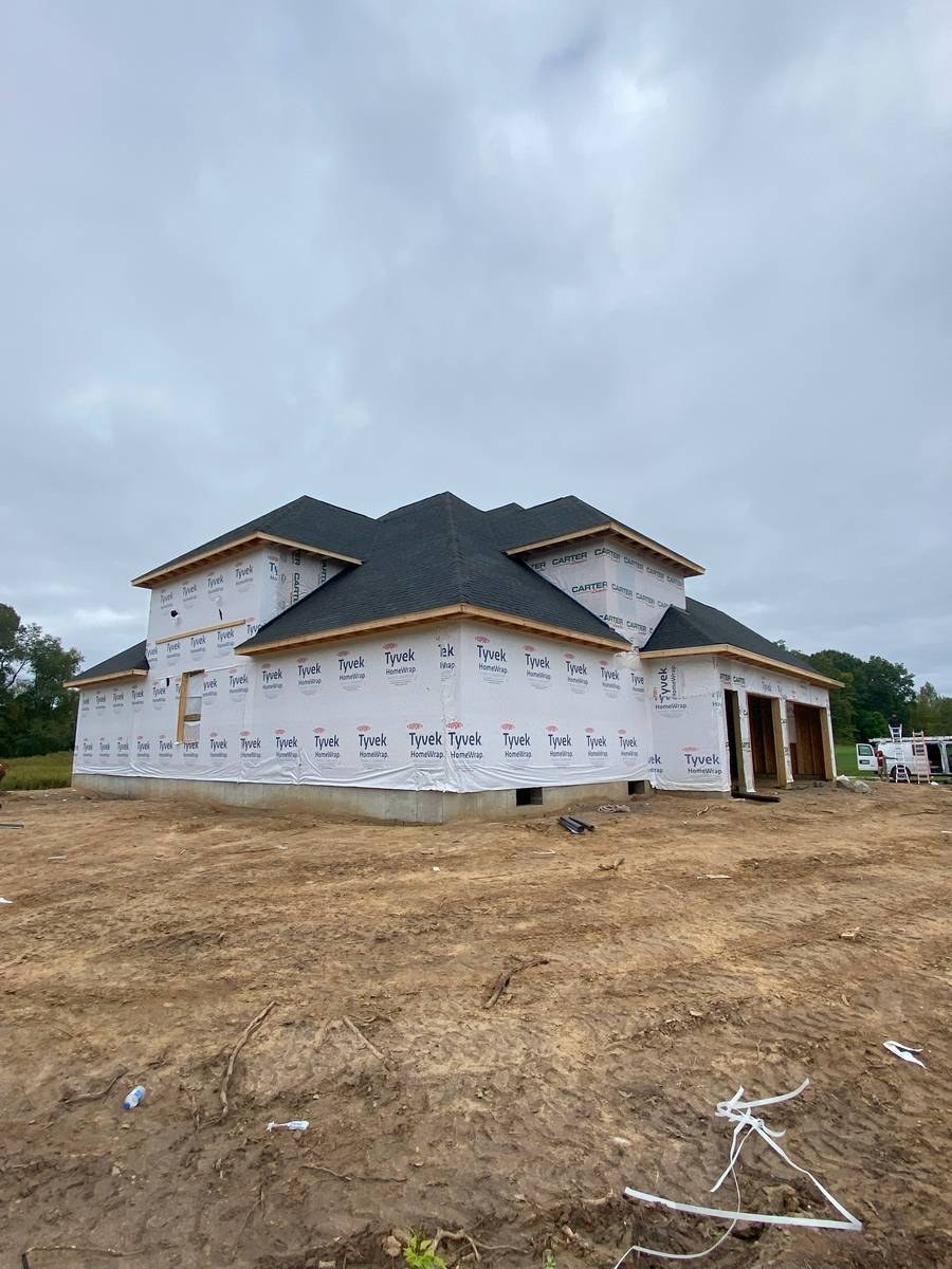 Newly framed custom home with completed roof and Tyvek house wrap, pre-siding