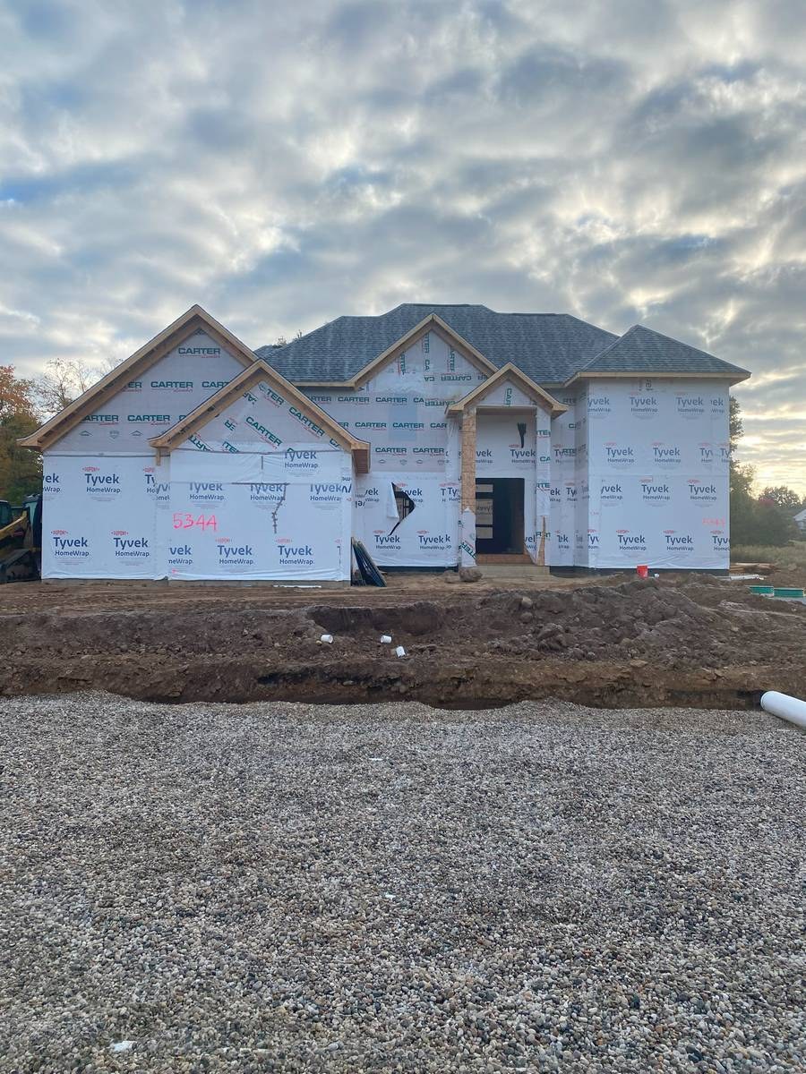 Custom home with roofing complete and gravel drive laid, nearing completion